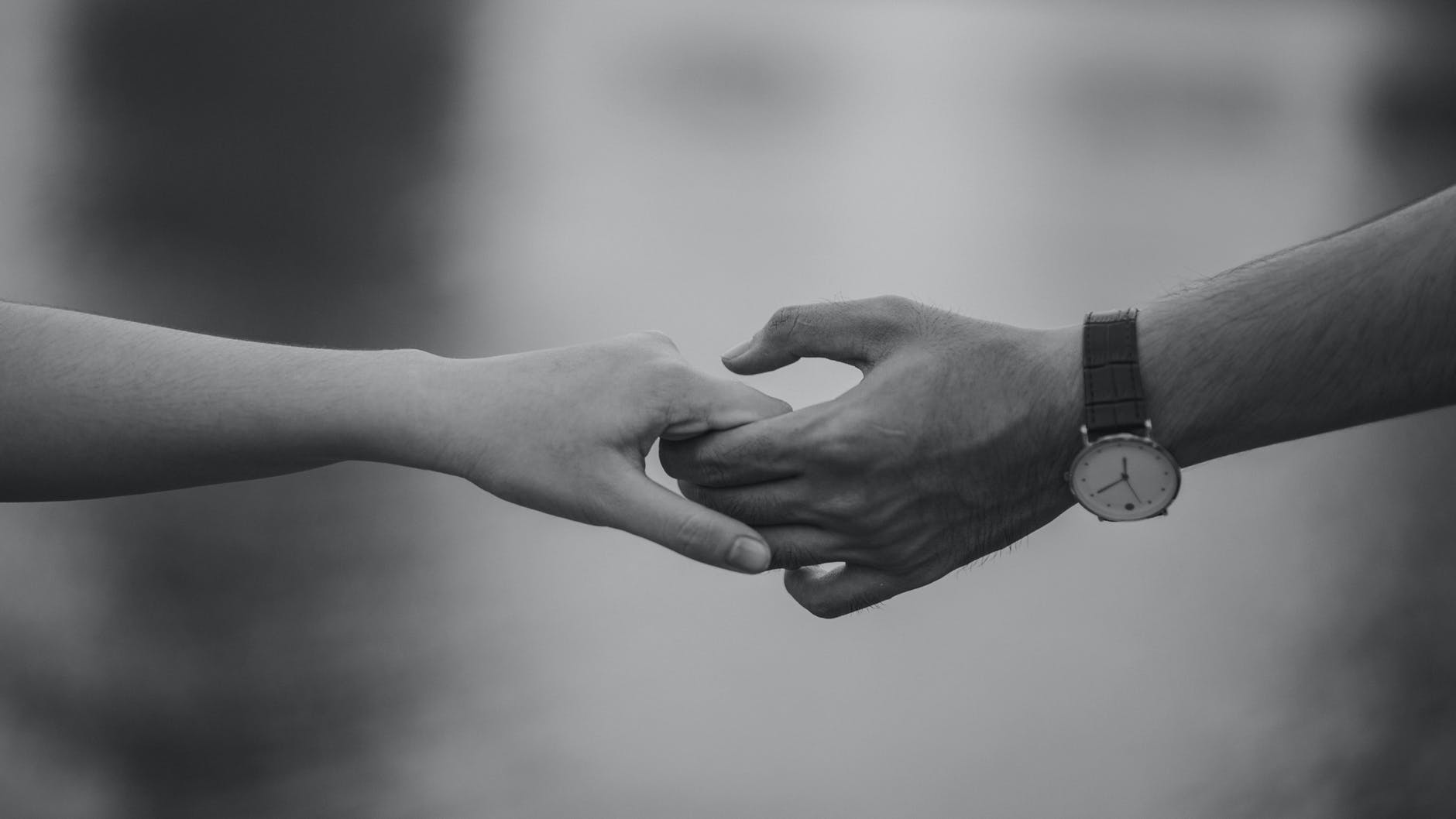 monochrome photo of couple holding hands