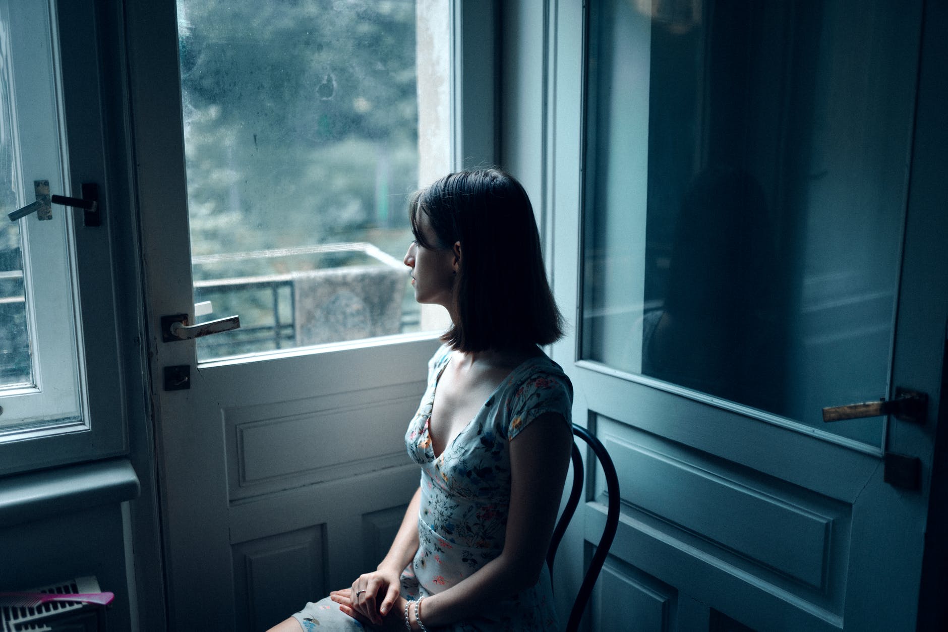 woman sitting near white wooden door